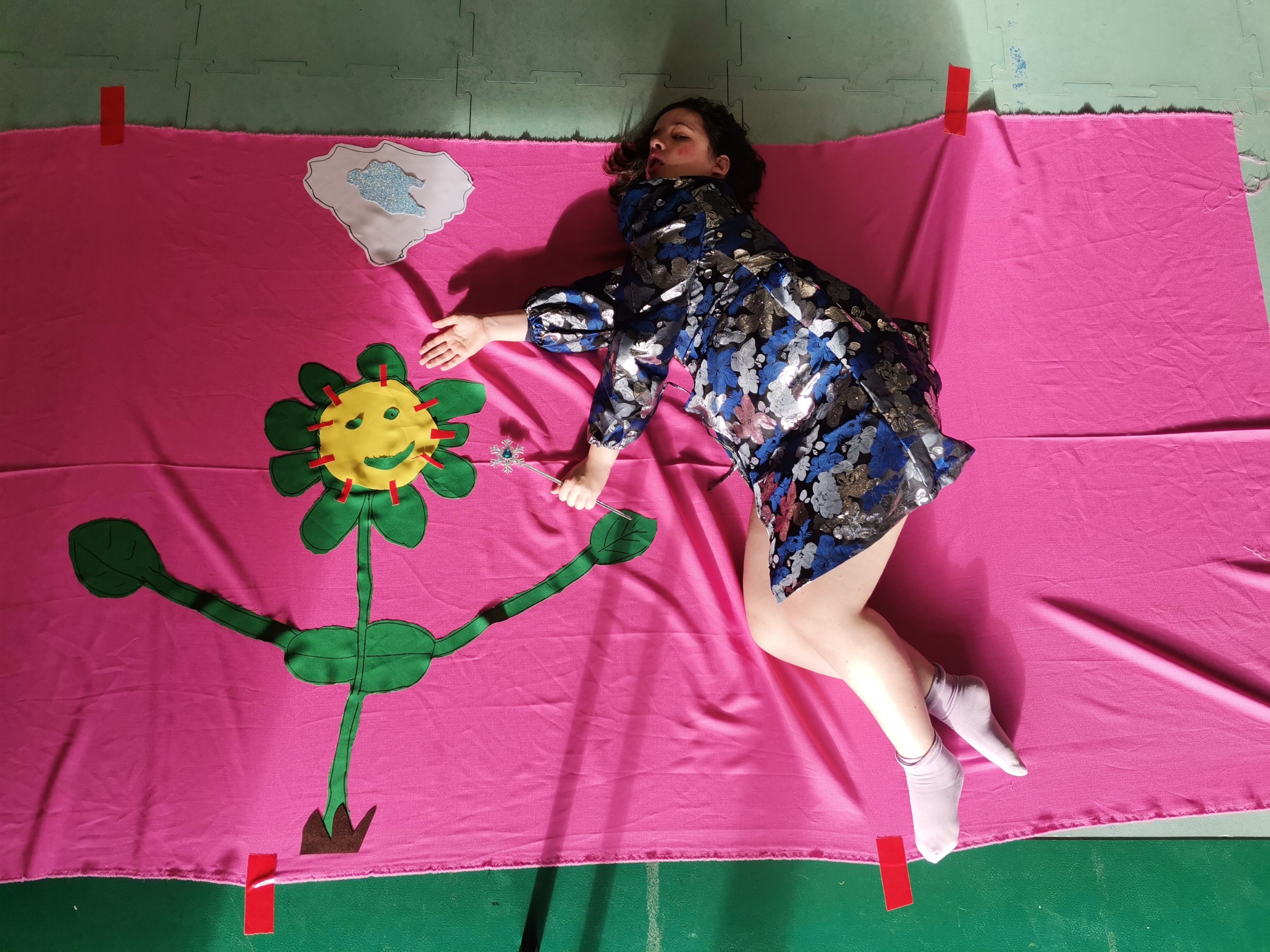 Arcadië_beeld deelneemster poseert op roze doek met grote bloem op
