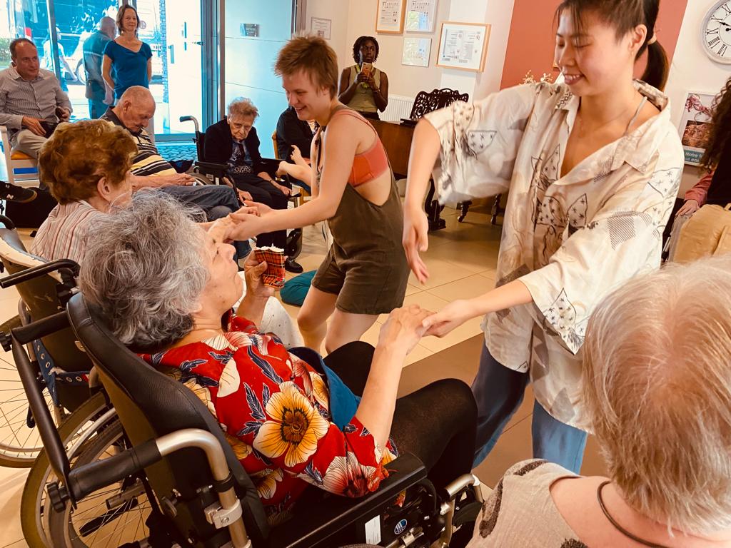 danskunst in residentie Bellevue in Vorst oude vrouw in rolstoel danst met jonge danseres